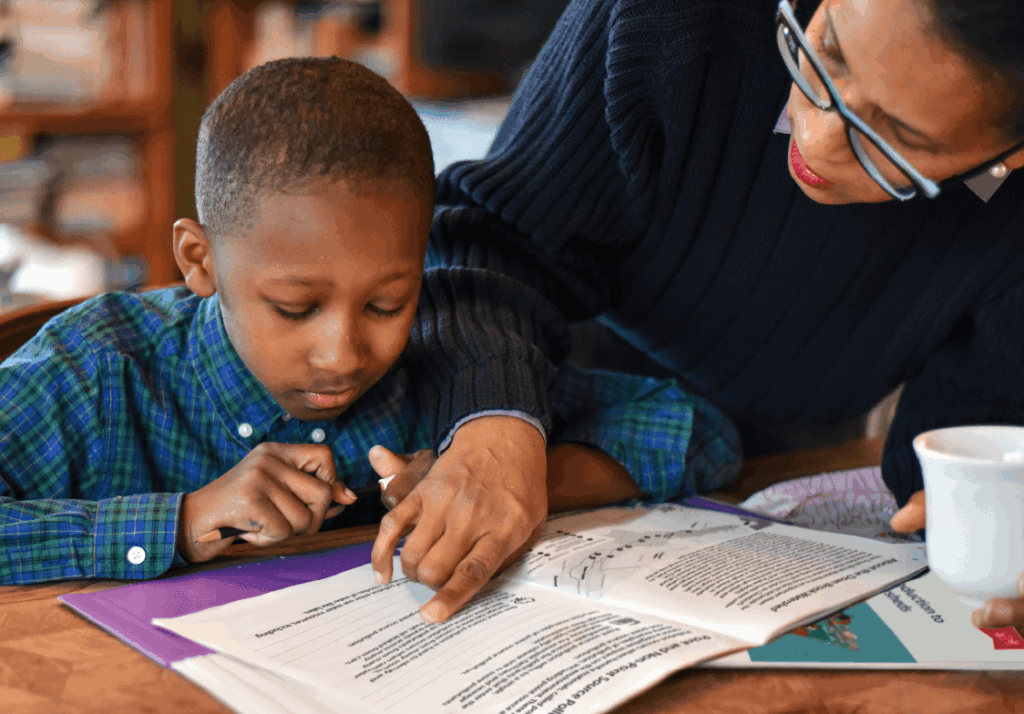 A teacher helps their student with understanding a page from the Watershed Science workbook.